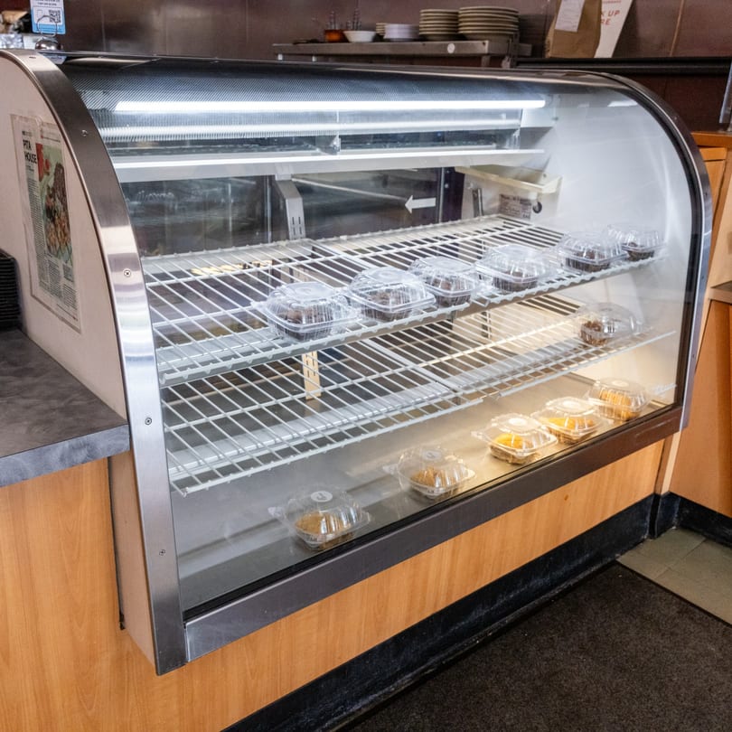 A glass display case filled with individually packaged desserts, including brownies and pastries.